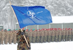 A soldier carries the NATO flag during German Minister of Defence Ursula von der Leyen's visit to German troops deployed as part of NATO enhanced Forward Presence (eFP) battle group in Rukla military base