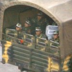 Chinese soldiers with riot shields sit in the back of an army truck as they pass through the city of Kangding, located around 400 kilometres (250 miles) west of Chengdu in Sichuan Province